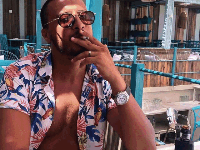 a man smoking a cigarette while wearing sunglasses