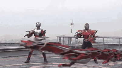 a couple of superheros are standing next to each other on a rooftop .