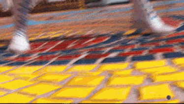 a blurry picture of a person walking on a yellow brick floor