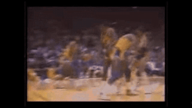 a blurry picture of a basketball game with a crowd in the stands