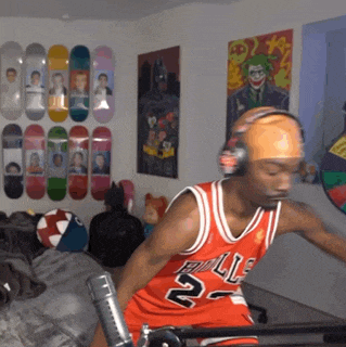 a man wearing a bulls jersey and headphones stands in front of a microphone