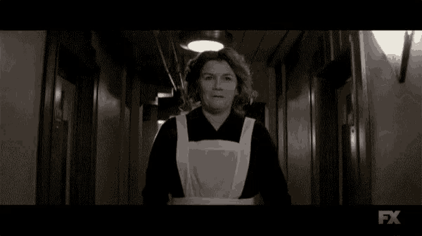 a black and white photo of a woman in an apron smiling .