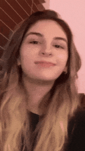 a close up of a woman 's face against a pink background