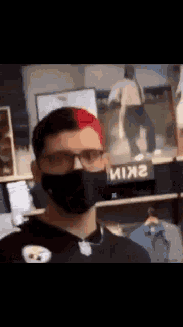 a man wearing a mask and glasses is standing in front of a store .