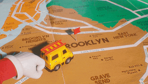 a yellow toy fire truck with a ladder on top is on a map