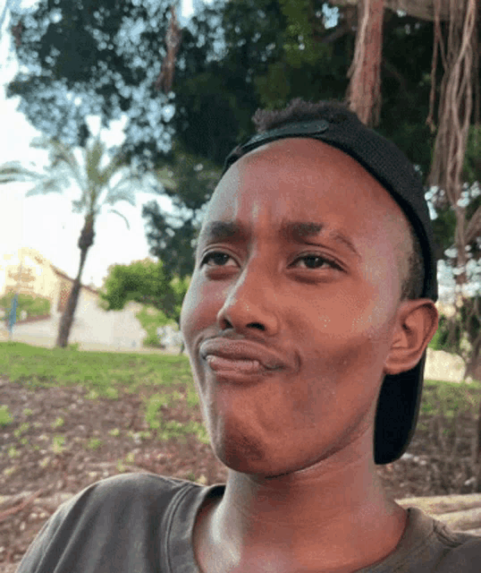 a man wearing a baseball cap is making a face