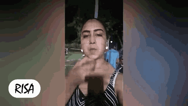 a woman is making a face while holding a cell phone .