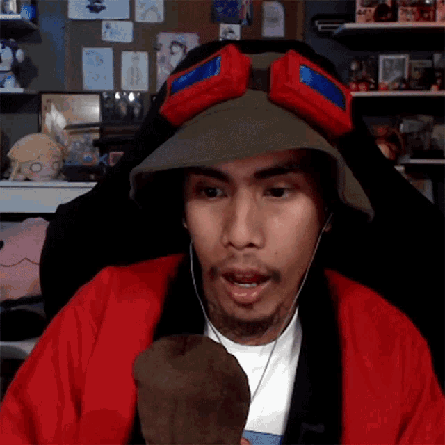 a man wearing a red jacket and a hat with goggles