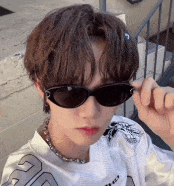 a young man wearing sunglasses and a white shirt with the number 20 on it