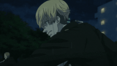 a man is standing next to another man in a dark room .