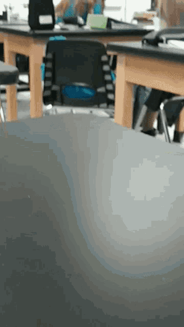 a person is sitting at a desk in a classroom with other students