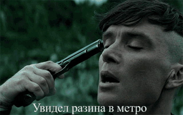 a man is holding a gun to his face with a caption in russian