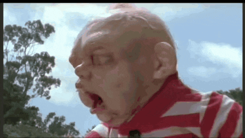 a close up of a baby 's face with a striped shirt on