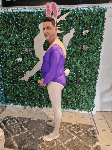 a man wearing bunny ears and a purple leotard