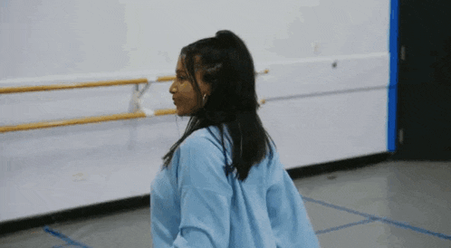 a young woman is dancing in a dance studio .
