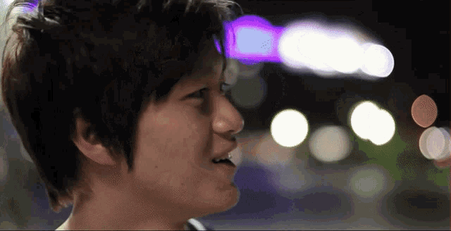 a close up of a person 's face with blurry lights behind them