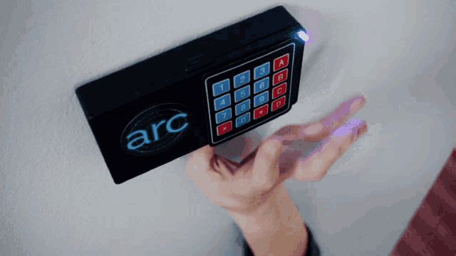 a person is holding a keypad that says arc