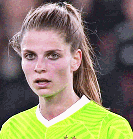 a close up of a woman 's face wearing a neon yellow shirt