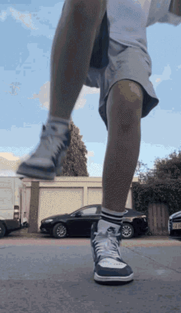 a person wearing a pair of nike shoes is standing on the sidewalk