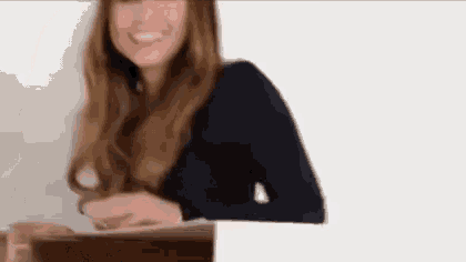 a woman with long hair is smiling and looking at the camera .