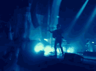 a man singing into a microphone on a stage