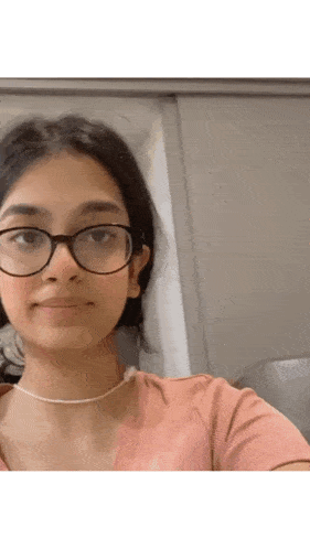 a close up of a woman wearing glasses and a necklace .