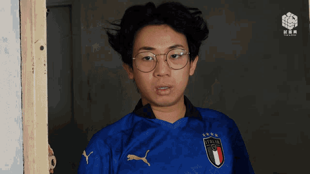 a man wearing a blue italia jersey making a face