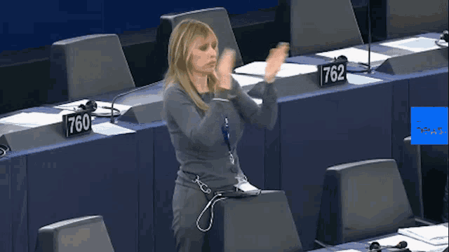 a woman stands in front of a podium with a sign that says 762