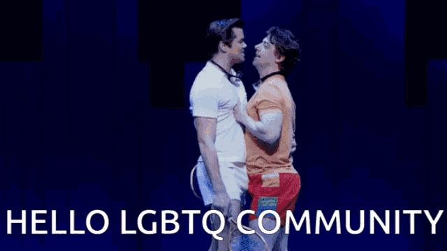 two men are facing each other on a stage with the words hello lgbtq community below them