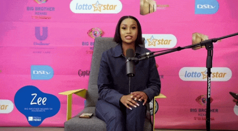 a woman sitting in front of a microphone with lotto star written on a pink background behind her