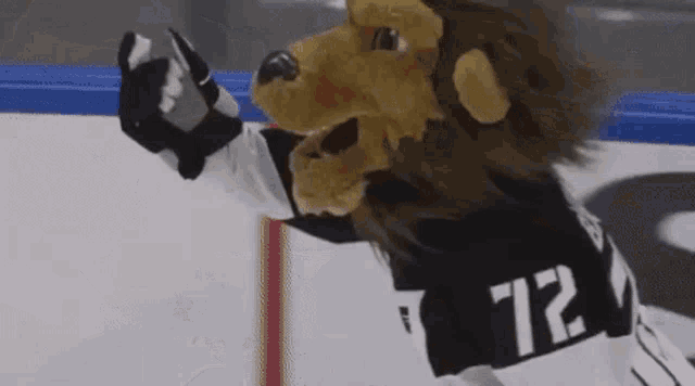 a mascot with a lion 's head and the number 72 on his jersey