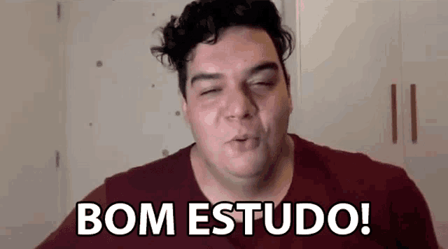 a man in a red shirt is making a funny face and saying bom estudo .