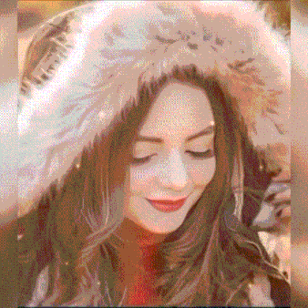 a woman is wearing a fur hat and smiling .