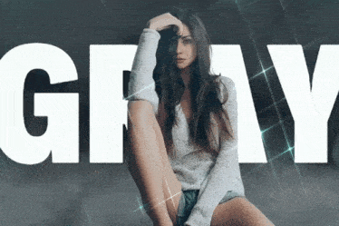 a woman is sitting in front of a large gray word