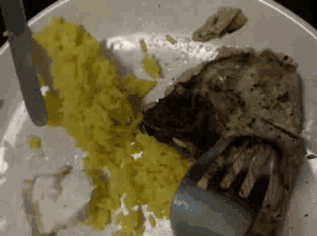 a plate of food with rice and meat and a knife and fork