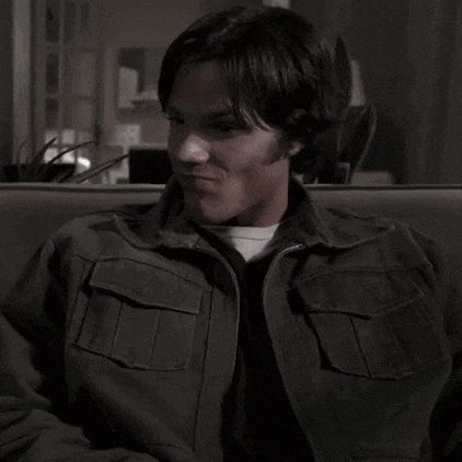 a man wearing a jacket is sitting on a couch