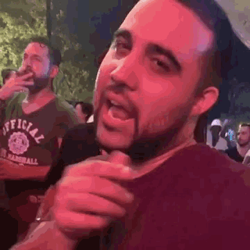 a man with a beard is wearing a shirt that says official on it .