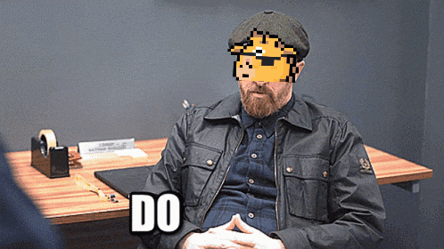 a man in a black jacket sitting at a table with the word do written on it
