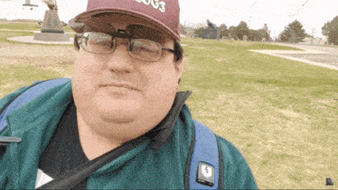 a man wearing glasses and a hat with the word dogs on it