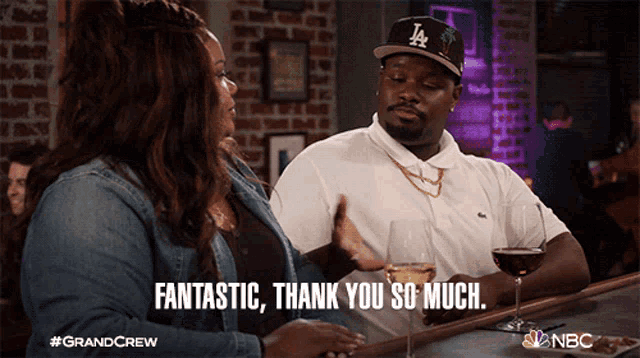 a man wearing a la hat is sitting at a bar with a woman and says fantastic thank you so much