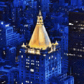 an aerial view of a city at night with a tall building in the middle