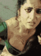 a close up of a woman 's face with a green top