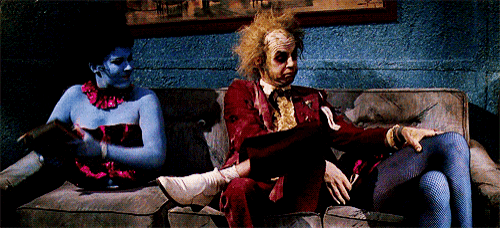 a man in a red suit sits next to a woman in blue