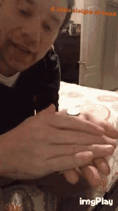 a man is holding a coin in his hands with the words a little sleight of hand behind him