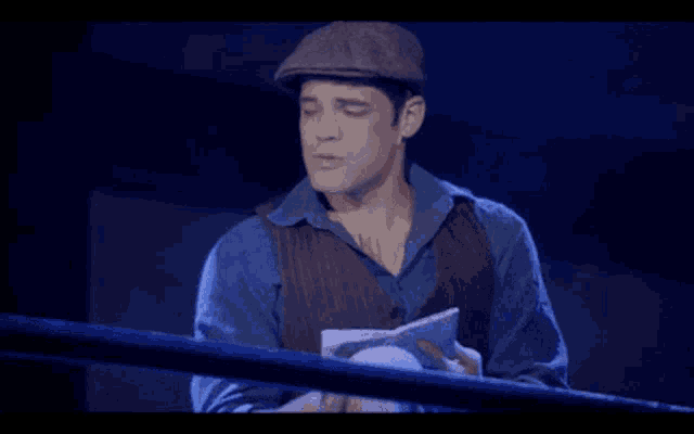 a man wearing a hat is reading a book