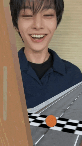 a man in a blue shirt is smiling and looking at a checkered road
