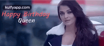 a woman with long hair is standing in front of a car with the words happy birthday queen written on the bottom .