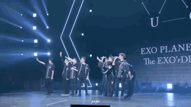 a group of people standing on a stage with a sign that says exo on it