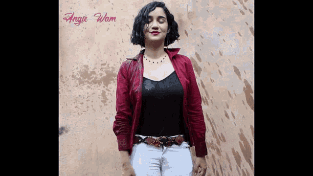 a woman standing in front of a wall with angie wom written on the top