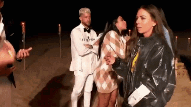 a group of people are standing next to each other on the beach at night .